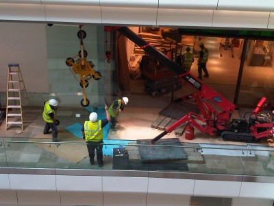 Team performing controlled manual handling of a glass panel